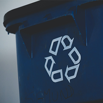 Recycling logo on a blue recycling bin
