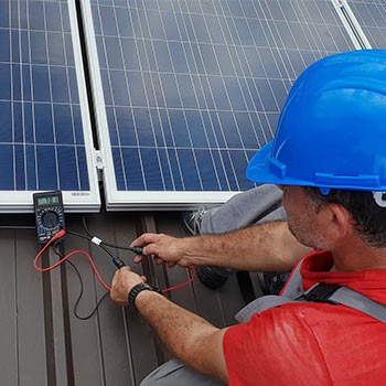 Electricals on a solar panel being tested by a man