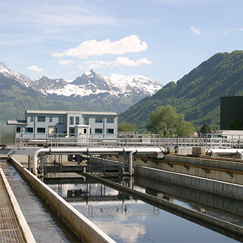 A backdrop of mountains with a wastewater treatment plant in front